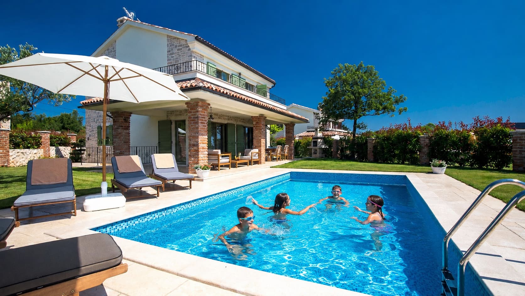 Children playing in the private pool at Family Villa Nika with garden on island of Krk