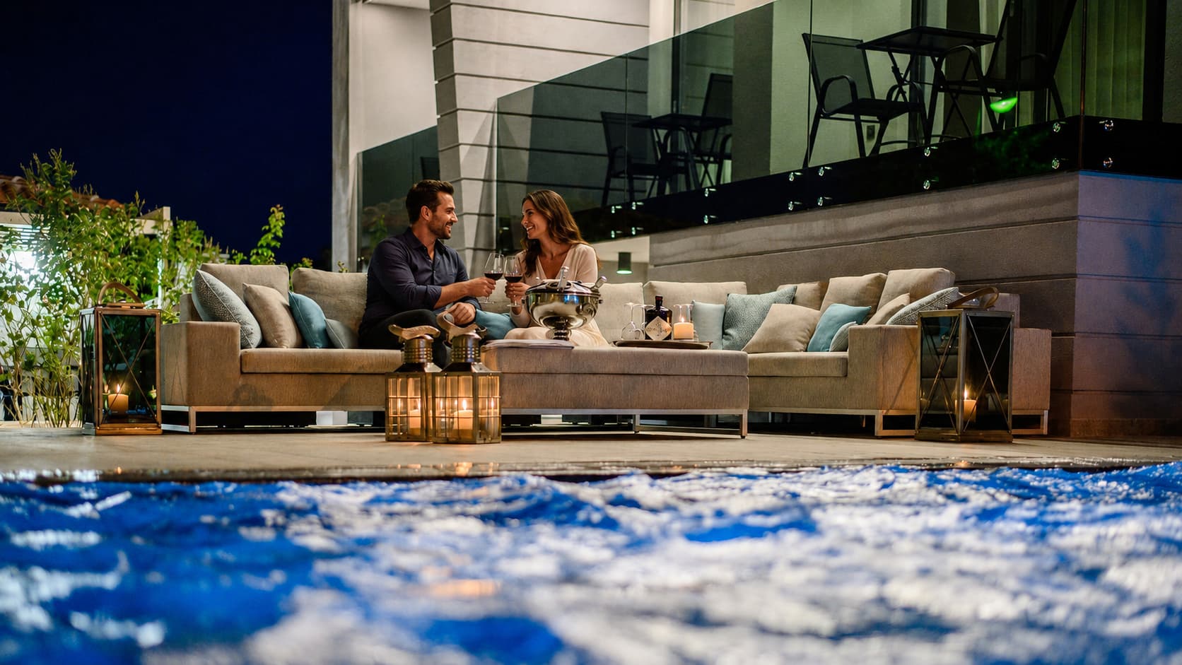 Couple relaxing by the illuminated pool terrace at Villa Curiera on Krk Island at night
