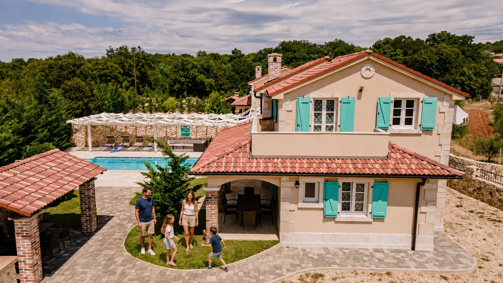 Family standing in fornt of Villa Kras with private pool and garden area on island of Krk