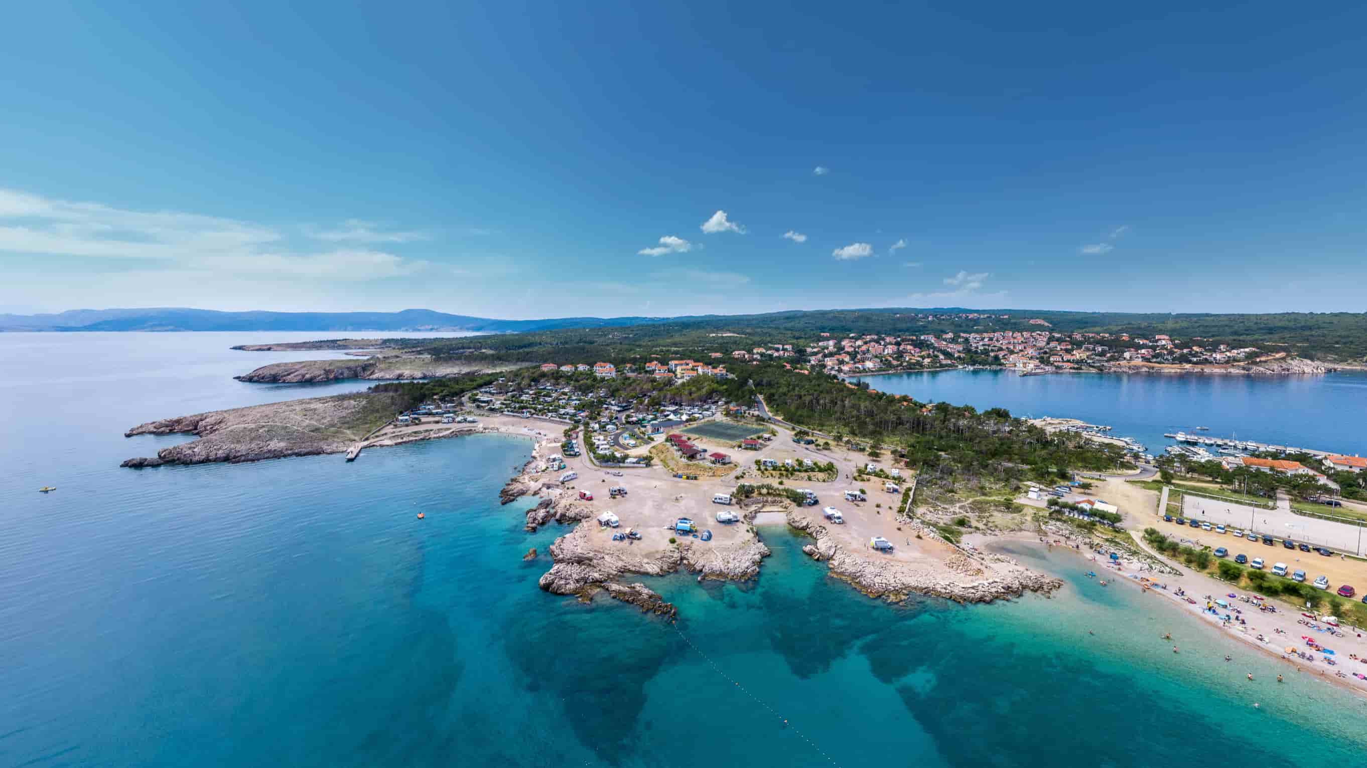 Aerial view of Šilo bay on Krk island with turquoise sea, beaches, and marina