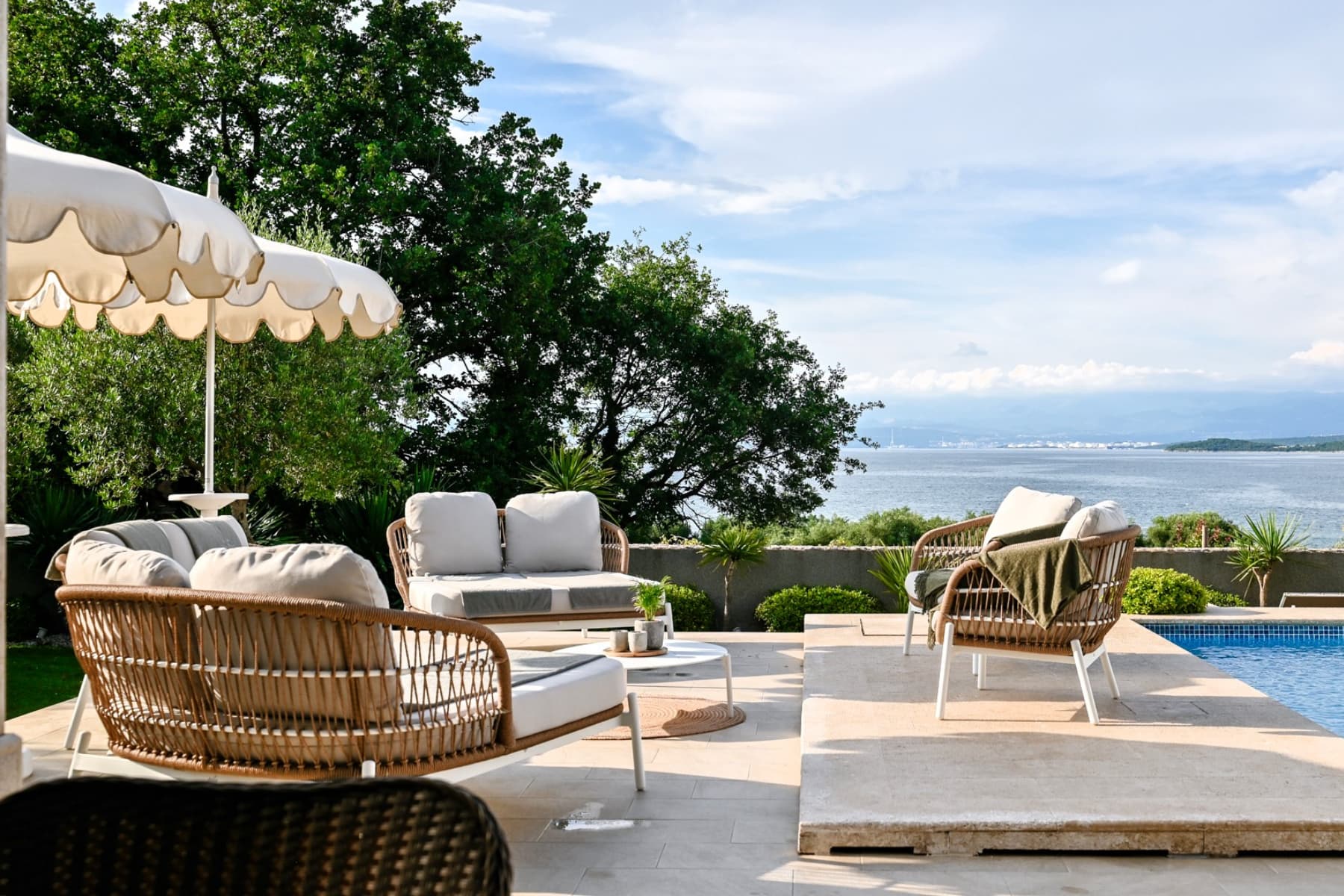 Outdoor terrace with lounge seating, pool area and sea view at Villa Prova 1 in Malinska, Krk